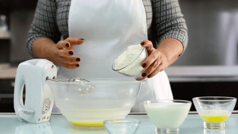 Crema di ricotta fatta in casa Woman preparing homemade ricotta cream with ingredients and mixer in the kitchen.