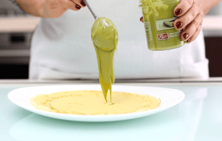 Pistachio Cream Being Spread on a Cake Pistachio cream being spread on a cake with a spoon, close-up shot.