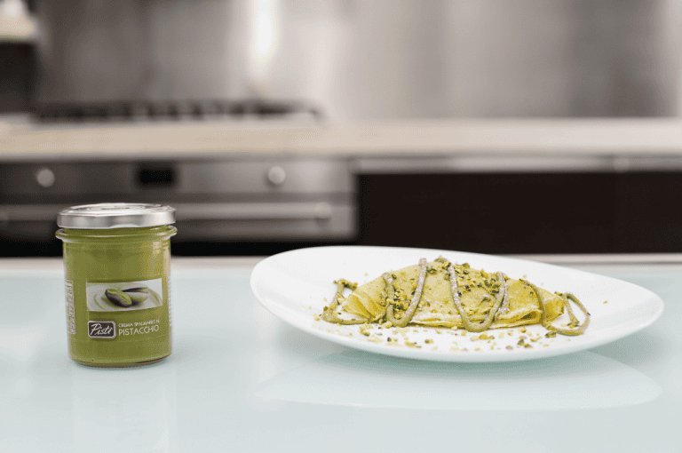 Pistachio Spread and Pistachio Paste Delicious pistachio spread in a glass jar with pistachio paste on a white plate.