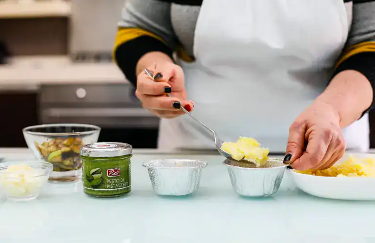 Pistì Artisanal Sicilian Pastry Preparation Person preparing Sicilian pistachio pastry with pistachio paste and ingredients.