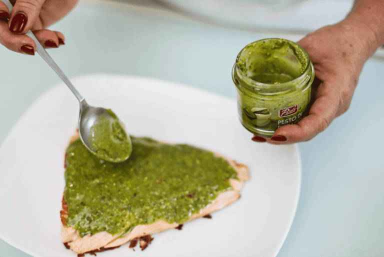 Pomodoro e pesto di pistacchio su pesce Pesce con pesto di pistacchio e pomodoro, pronto da servire.