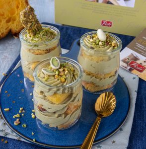 Artisanal Sicilian desserts in glass jars with pistachios and cream.