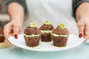 Delicious chocolate cupcakes with cream filling, topped with crushed pistachios.