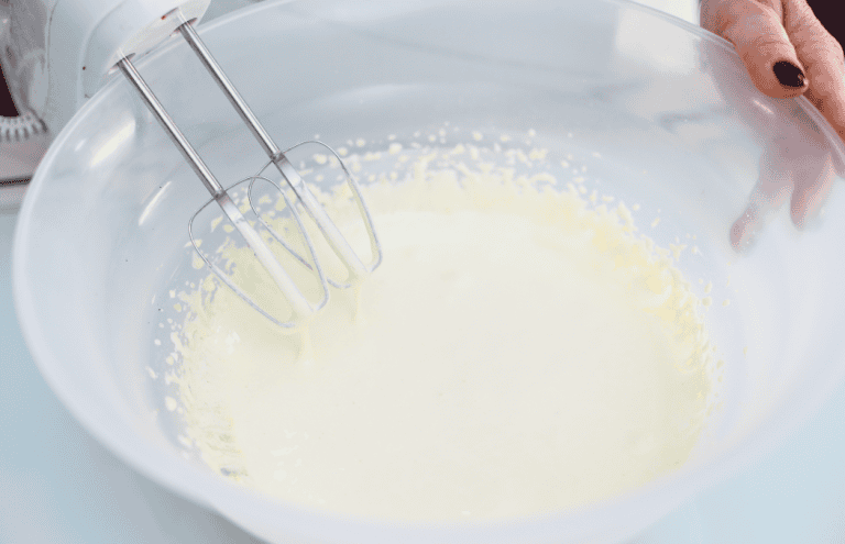 Festa di cucina con fruste elettriche Mixing batter in a large bowl for dessert preparation.