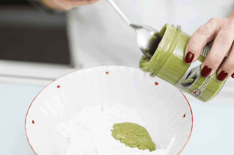 Crema di pistacchio artigianale siciliano Artisanal Sicilian pistachio cream being prepared with a spoon.