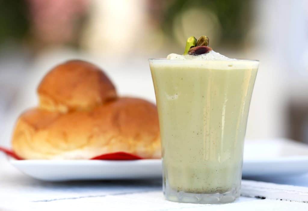 Creamy pistachio dessert in a glass with pistachio garnish.
