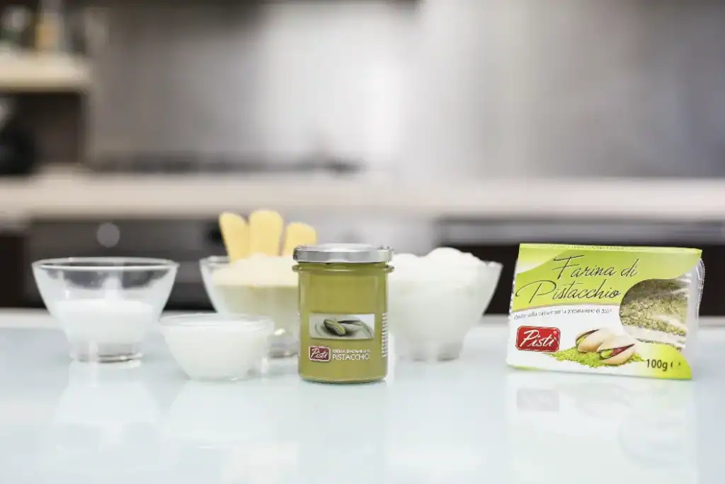 Crema di Pistacchio Siciliano Jar of Sicilian pistachio cream with ingredients on a kitchen counter.