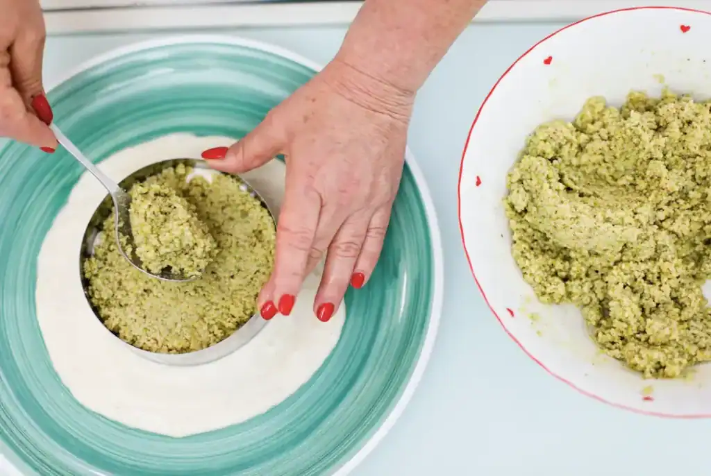 Handmade Sicilian pistachio filling preparation Woman preparing pistachio filling with a spoon in a bowl.