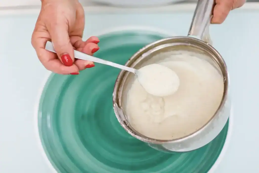 Crema di ricotta siciliana Creamy Sicilian ricotta cheese being served with a spoon.