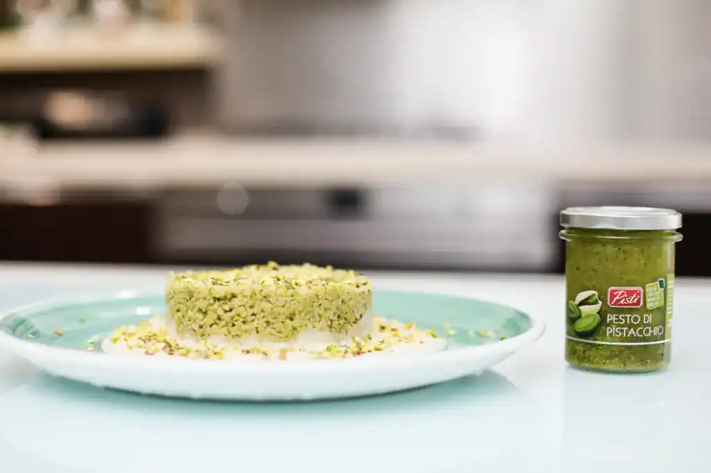 Pistachio Pesto on Plate Fresh pistachio pesto served on a plate with a jar of pesto beside it.