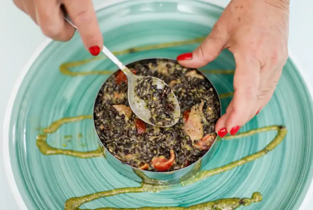Sicilian Black Rice with Seafood Black rice with seafood and herbs in a bowl.