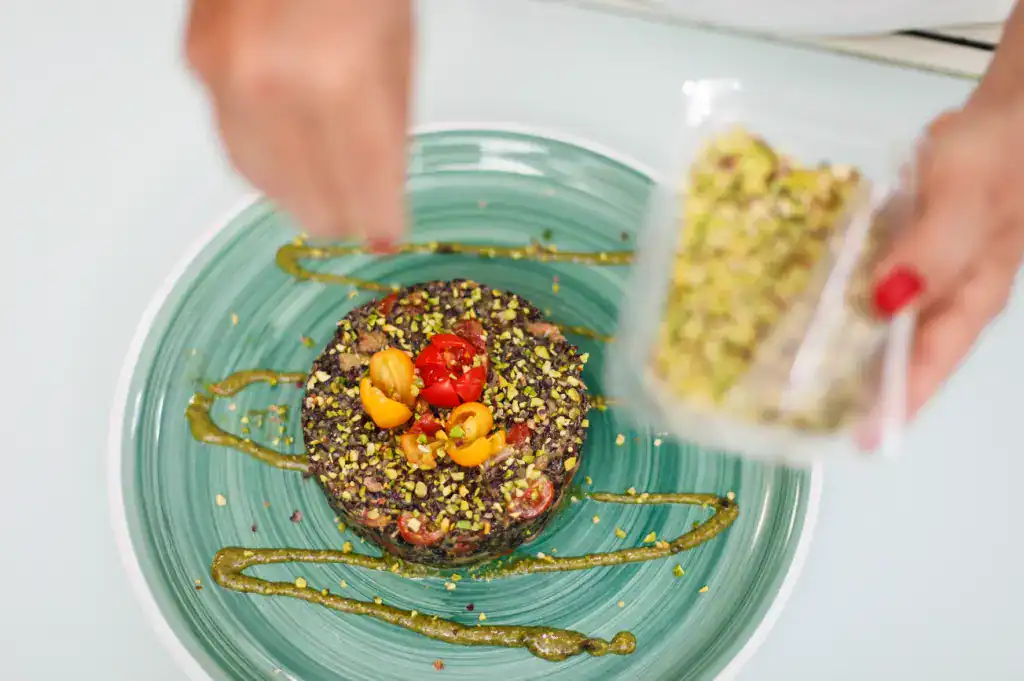 Delicious Sicilian artisanal sweet dessert Artisanal Sicilian sweet dessert with pistachios and berries on a turquoise plate.