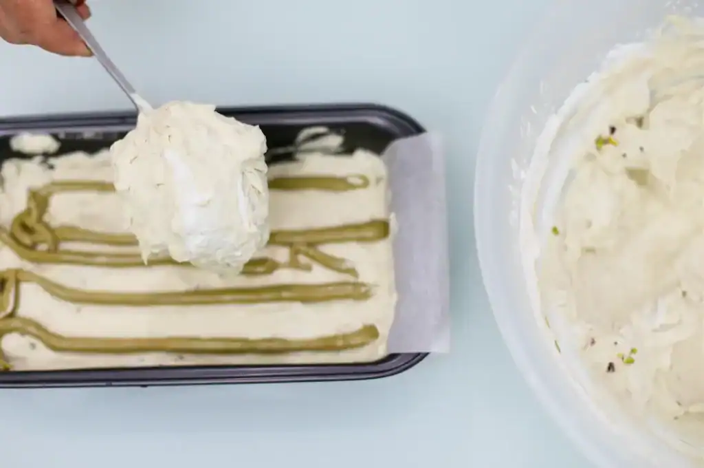 Creamy Sicilian ricotta dessert with pistachio topping Sicilian ricotta dessert with pistachio topping in a black tray.