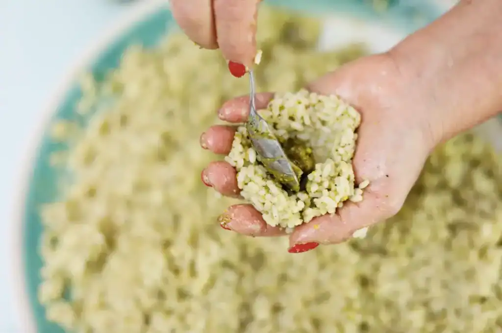 Pistì Sicilian Artisanal Sweets Hand scooping traditional Sicilian pistachio sweet with a spoon.