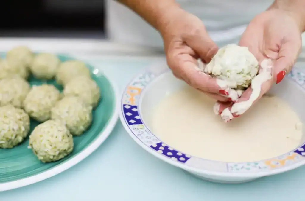 Frittelle di ricotta siciliane Hand shaping ricotta balls for Sicilian sweet fritters.