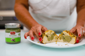 Hand holding a pistachio-filled Sicilian cake, ready to be served.