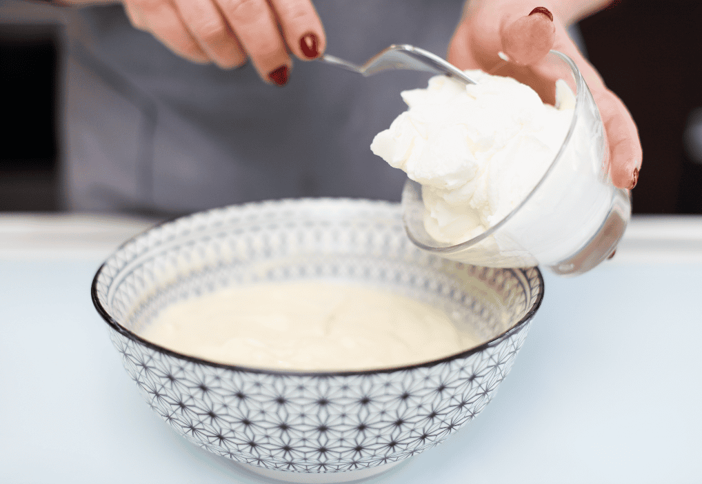 Pomodoro di ricotta fresca Fresh ricotta cheese being scooped into a bowl.