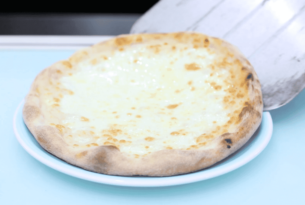 Pizza Margherita fresca Fresh Margherita pizza with melted cheese on a thin crust.