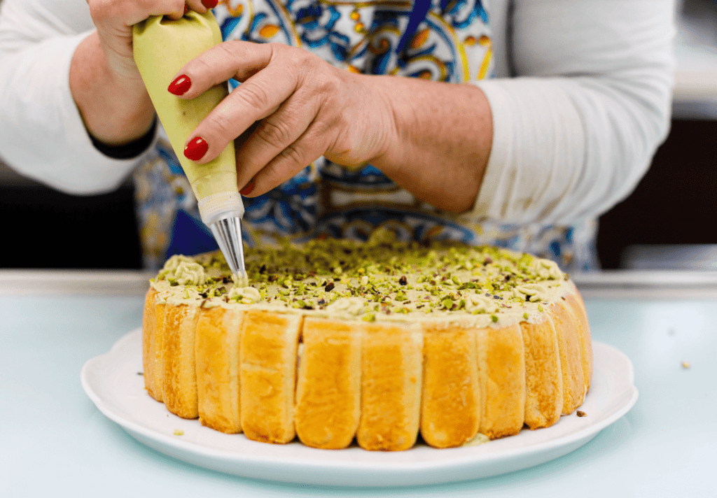 Crema di pistacchio su torta siciliana Pistachio cream being piped onto a traditional Sicilian cake.