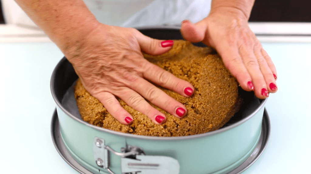 Torta di mandorle artigianale Mani che pressano una torta di mandorle in uno stampo rotondo, preparazione di dolce siciliano artig.