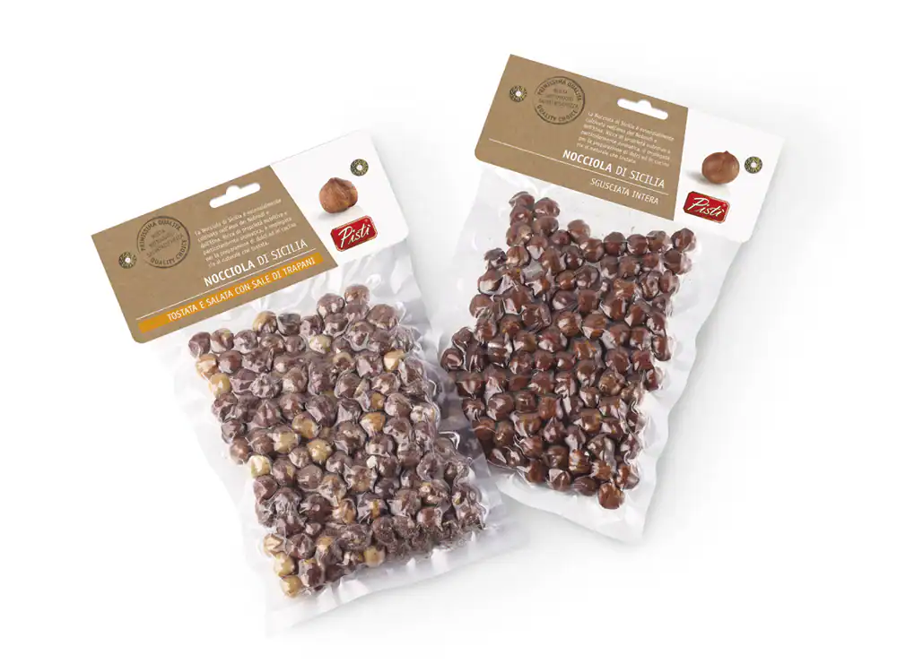 Two packs of Sicilian hazelnuts and cocoa nibs for artisanal desserts.