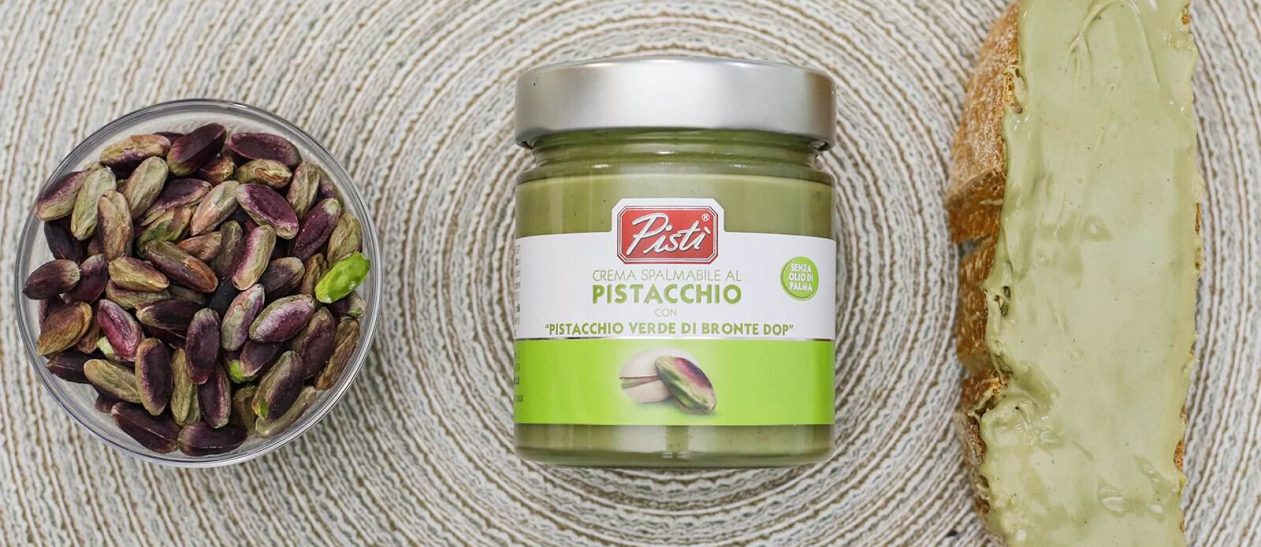 Pistachio cream jar with pistachios and bread with pistachio spread.