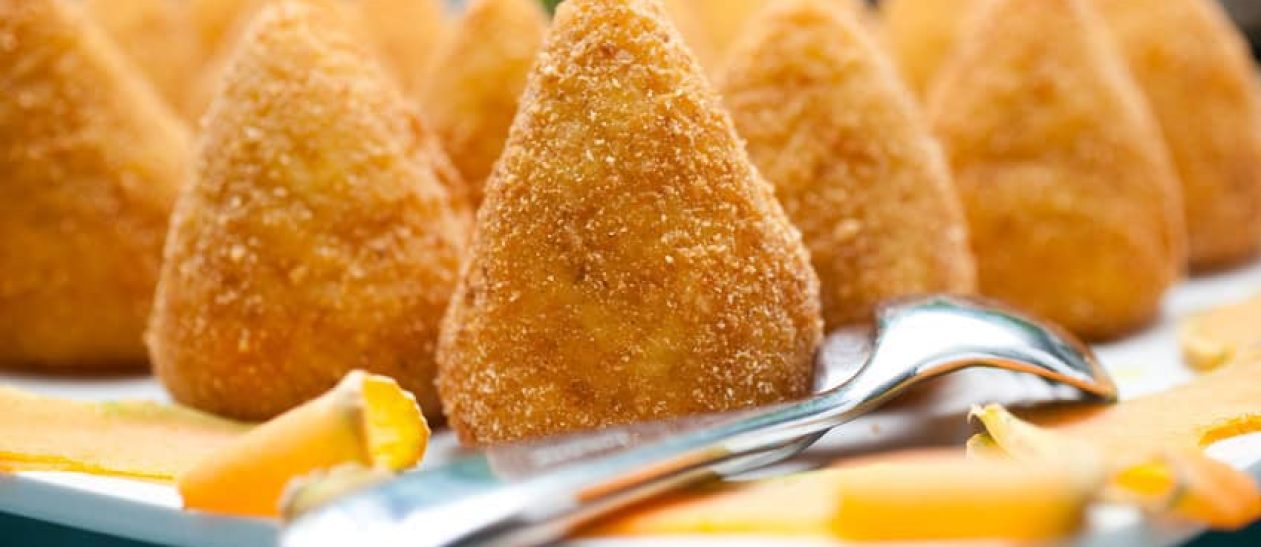 Arancini Siciliani croccanti e dorati con ripieno di formaggio e ragù.