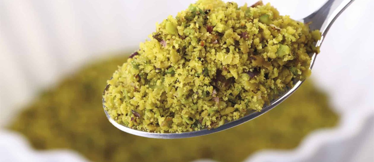 Close-up of green Sicilian pistachio dessert on a spoon.